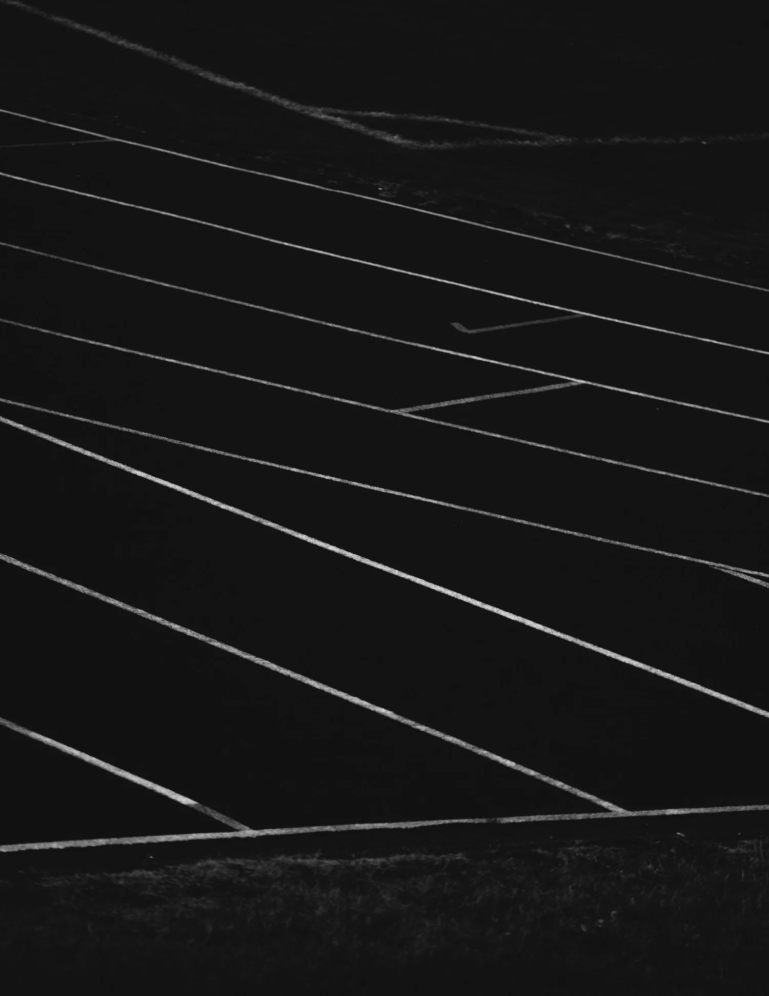 An empty athletic running track with multiple lanes marked in white